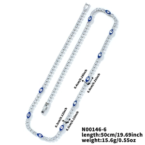 Detalle del collar de cobre con ojos esmaltados azules y piedras de circón transparentes