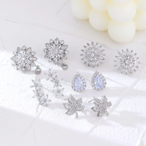 Détail d'un lot de boucles d'oreilles en zircon argenté avec motifs tournesol et érable