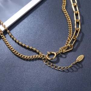 Collier doré multi-rangs avec pendentif cœur et étiquette Hand Made sur fond gris