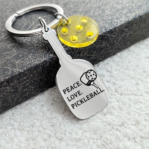 Pickleball keychain featuring a stainless steel paddle pendant and yellow ball charm