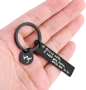 Macro view of matte black stainless steel Drive Safe keychain held in a person's palm