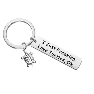 Stainless steel turtle keychain with inspirational engraved plate on white background