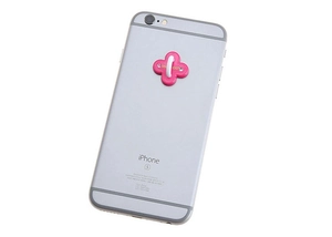 Detailed close-up of a pink cross-shaped phone ring stand on a silver smartphone back