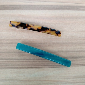 Detail of acetate leopard print spring hair clips in amber and teal blue finishes