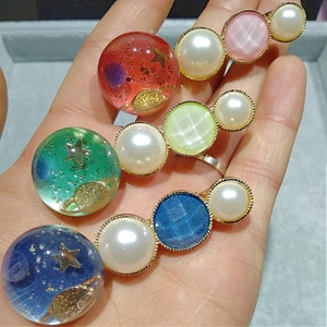 Détail de trois barrettes en résine avec paillettes étoilées, lunes et perles d'imitation