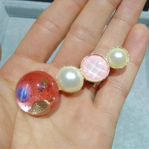 Vue détaillée des breloques en résine étoilée et perles sur une pince à cheveux dorée