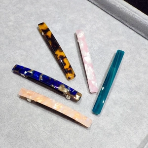 Close-up of leopard and marble pattern acetate hair clips on gray velvet display tray