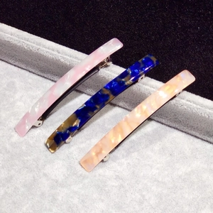 Detailed macro view of three patterned acetate hair clips in marble and tortoiseshell