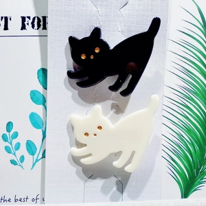 Detailansicht süßer schwarz-weißer Katzen-Haarclips auf Displaykarte mit Goldakzenten