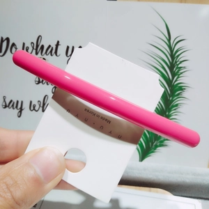 Gros plan sur une pince à cheveux rose brillant sur carte avec une finition laquée