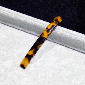 Close-up of tortoise shell pattern acetate hair clip with a silver metal spring clasp