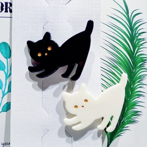 Nahaufnahme von schwarz-weißen Acryl-Katzen-Haarklammern auf weißer Display-Karte