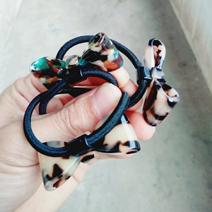 Close-up of tortoise shell and colorful resin bow hair ties with black elastic bands