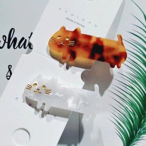 Detail view of acetate cat hair clips with amber and pearl textures on display card
