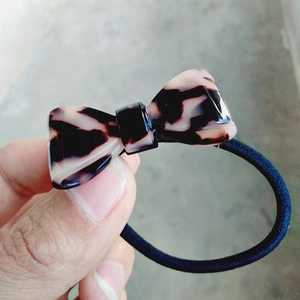Close-up of leopard print acetate bow hair tie with durable black elastic band