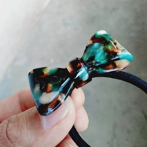 Detailed view of leopard tortoiseshell bow hair tie with strong black elastic band