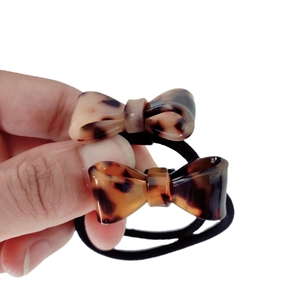Set of two leopard print bow hair ties with thick black elastic bands on a white background