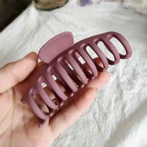 Détail d'une grande pince à cheveux violet mat avec une texture en résine givrée