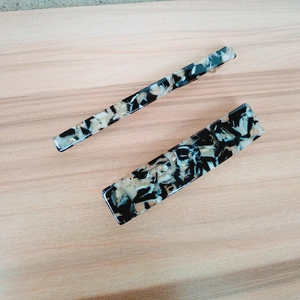Close-up of elegant marble pattern hair clips on natural wood background