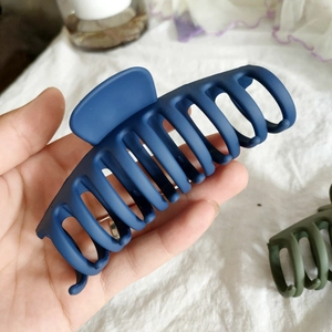 Gros plan d'une grande pince à cheveux mate bleu marine montrant la taille et la texture