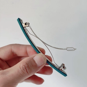 Détail de la pince à cheveux 10cm montrant le ressort argenté et le fini sarcelle