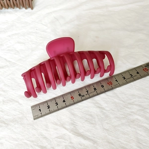 Détail d'une grande pince à cheveux mate magenta de 14cm avec règle de mesure
