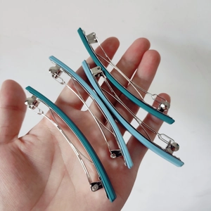 Lot de barrettes mates de 10cm en bleu et cyan tenu à la main pour l'échelle