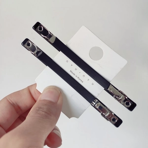 Minimalist black pearl hair clip set with matte finish on brand card shown in hand