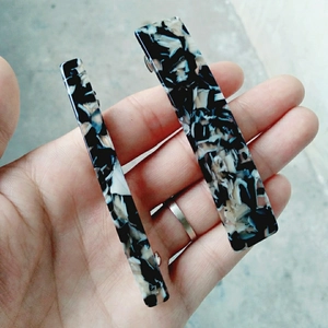 Close-up of rectangle acetate hair clips with black and white marble ink texture