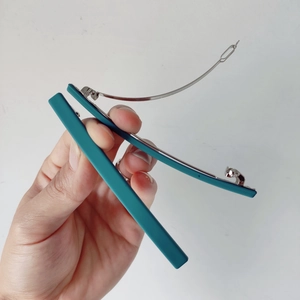 Vue détaillée des barrettes à cheveux bleu sarcelle mat avec fermoirs métalliques