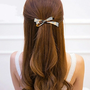 Elegant tortoiseshell bow hair clip accessory shown on a model from a back view