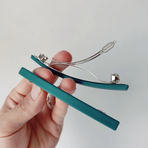 Vue détaillée de la barrette mate vert foncé de 10 cm montrant le clip à ressort