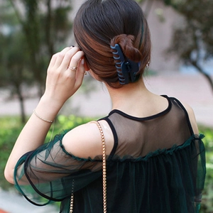 Pince à cheveux mate bleu marine pour femme présentée sur un modèle dans un cadre extérieur