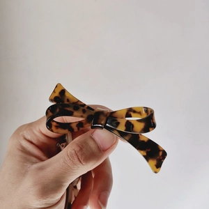 Detail view of the tortoiseshell leopard pattern bow hair clip in acetate material