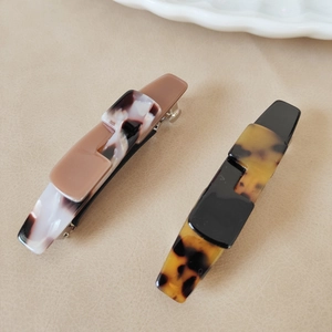 Chic acetate hair clip set with leopard print and marble textures on beige background