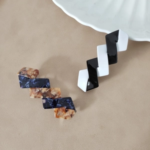 Elegantes Haarspangen-Set mit Monochrom- und Marmorstruktur auf Lederhintergrund