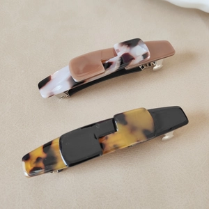 Macro shot of two vintage tortoiseshell acetate hair clips with metal spring mechanisms