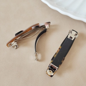Detail view of acetate leopard print hair clips with silver metal spring and anti-slip bar