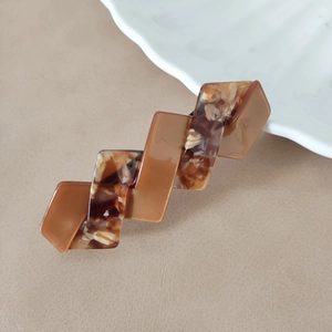 Detail einer schicken Haarspange mit Marmormuster und geometrischem Zackendesign