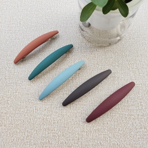 Detail view of five matte large spring hair clips in Morandi colors with metal backing