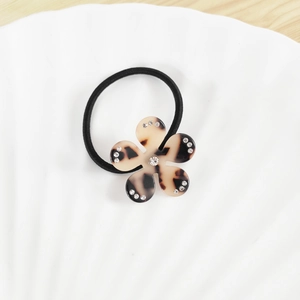 Détail d'élastique à cheveux avec fleur léopard, cristaux et bande élastique noire
