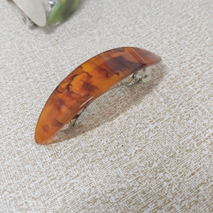 Macro shot of an amber marbled hair barrette with a sturdy silver metal spring clip