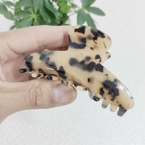 Primo piano di un grande fermaglio per capelli in acetato tartarugato con struttura seghettata