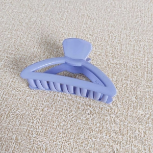 Détail de la pince à cheveux triangulaire ajourée violet lavande avec ressort en métal