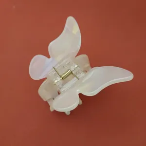 Vue détaillée d'une pince à cheveux papillon en acétate crème nacré pour femme