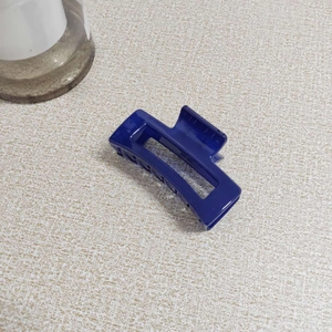 Detail of dark blue rectangular hollow hair claw clip with multi-tooth design