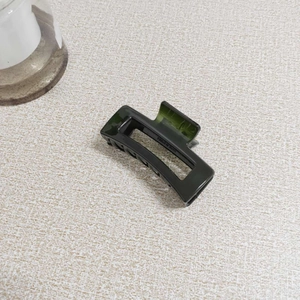 Detailed close-up of dark green jelly resin hair claw with sturdy internal metal spring