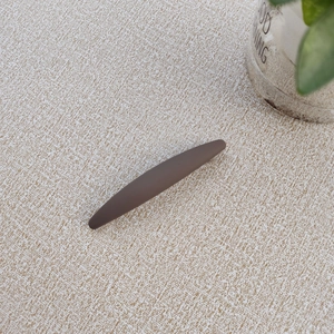 Minimalist matte dark brown long hair clip displayed on a textured beige surface