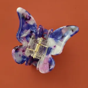 Détail de la pince à cheveux papillon en acétate avec texture marbrée bleue et violette