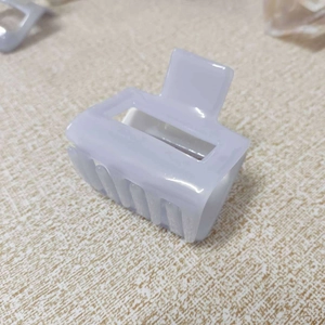 Close-up of a hollow rectangular lavender hair claw clip with glossy finish and metal spring